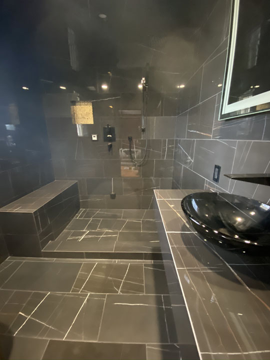 modern minimalist grey theme bathroom with same tile wall and flooring