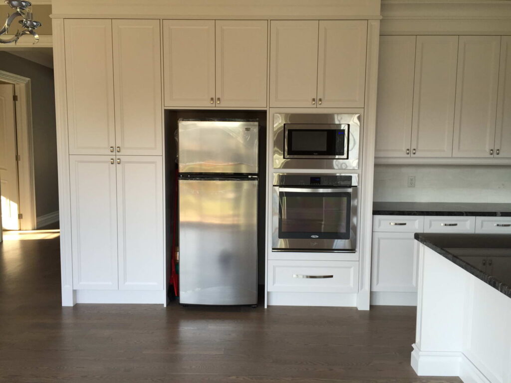 fridge and over installation with white storage cabinets