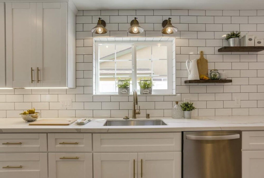 kitchen renovated with white cabinets and golden hardware and white marble countertop